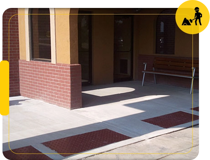 A building with a bench and a sidewalk.