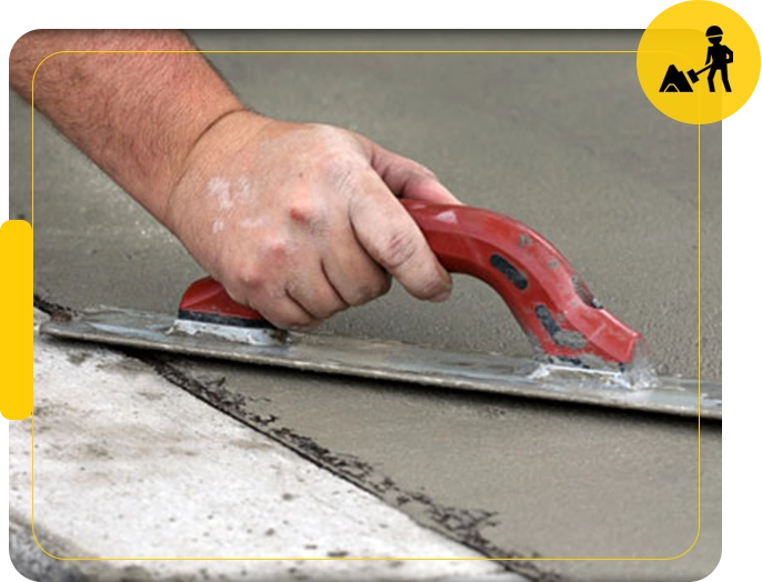 A person using a tool to smooth concrete.