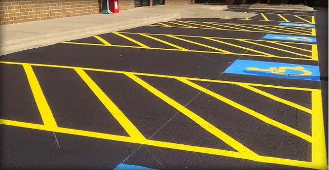 A parking lot with yellow lines and blue stripes.