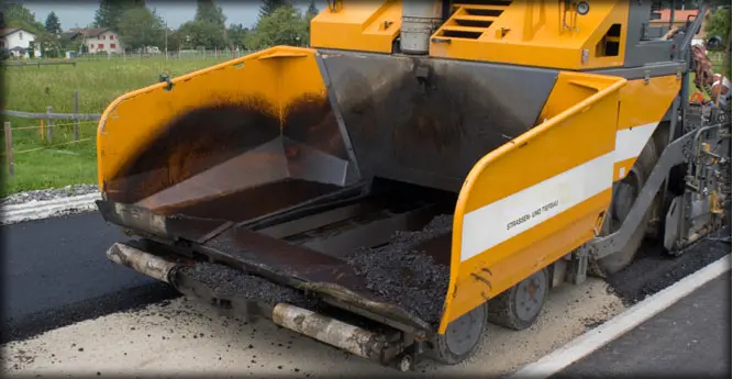 A yellow truck with a large bed of dirt.