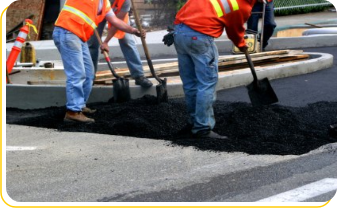 A group of men working on the side of a road.