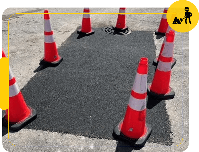 A group of orange and white cones on the ground.